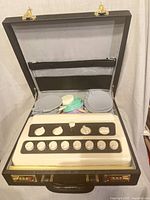 Open case showing stimulator, electrode pads and cords