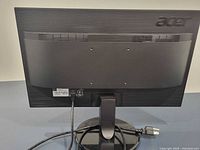 Rear view of Acer monitor showing stand, ribbed back, power cord attached