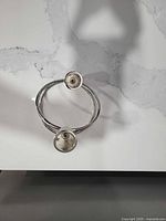 Top view of polished steel spiral candle holder showing two cup sockets