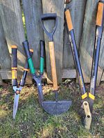 Group shot of all four garden cutting tools leaning against fence