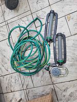 Hose coiled with two oscillating sprinklers, circular sprinkler visible