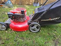 Left side view of red deck mower, fabric bag attached