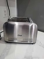 Angled front view of stainless steel Master Chef four-slice toaster