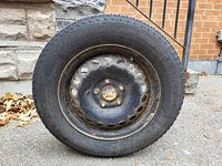 Full view of tire mounted on steel rim showing overall condition
