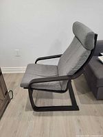 Profile view of IKEA Poang chair showing cushion, headrest and black frame