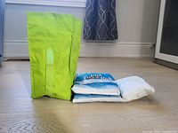 Side view of green cooler bag with two cooling packs beside