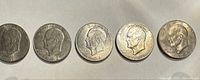 Group image of all five Eisenhower dollars obverse visible