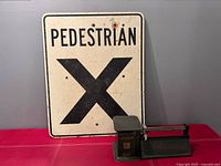 Overall view of pedestrian crossing sign beside postal scale