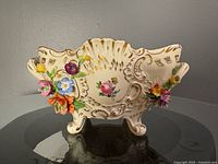 Front view showing applied flowers, hand-painted bouquet, four feet, gilt accents