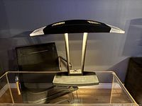 Front view of black postmodern desk lamp on glass desk