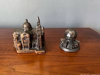Both copper souvenir paperweights side by side