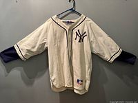 Full front view of cream Yankees jersey on hanger