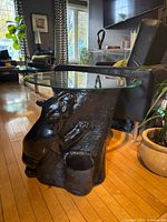 Full view of accent table showing panther base and glass top