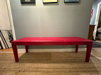 front view of red vinyl bench against wall