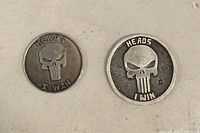 Obverse of both coins showing Punisher skull and text "Heads I Win"