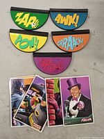 Five semicircular stands and four Batman trading cards laid out