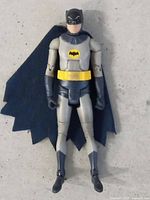 Front view of Batman figure showing suit, emblem, belt and cape