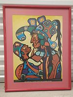 Front view of framed Norval Morrisseau print in red frame