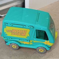 Side view of turquoise Mystery Machine van playset with decal and yellow wheels