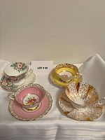Four teacup and saucer sets displayed