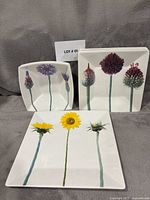 Front view showing large platter and two bowls with floral stem design