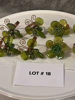 Group view of all eight napkin rings showing butterfly and flower designs