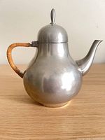 Full side view of pewter teapot showing shape, handle, spout