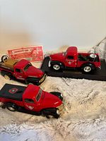 All three red Ford pickup coin banks displayed together with Canadian Tire certificate visible.