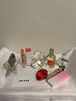 Group shot of all perfume bottles and decorative bottles on white fabric