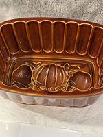 Interior of loaf pan showing embossed pumpkin, apple, pear design