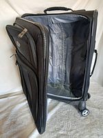 Suitcase open showing interior lining and front pocket open