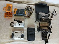 Overhead group shot of all five cameras with accessories