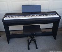 Front view of Donner digital piano on stand with bench and music rest