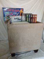 Lot overview showing fitness kit, Palm NRG box, VHS sets, cabinet