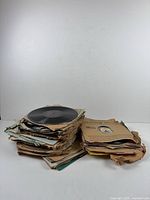 Stack of roughly forty 78 rpm records in worn paper sleeves