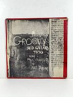 Front cover of Groovy LP with brick wall artwork, red tape on spine