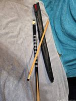 Full view of two-piece cue separated, alongside soft case