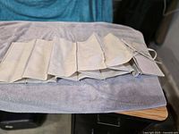 Folded cream cloth hanging shoe rack showing multiple compartments