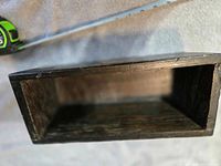 Interior view of wooden box showing open top and dark stained interior