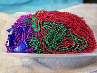 Pile of multicolored Mardi Gras bead strands in red, green, purple and blue