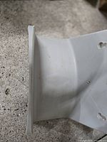 side profile of grey plastic hose holder showing curved shape and mounting flange