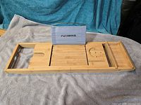 Top view of bamboo bathtub tray showing tablet stand, wine glass slot, phone slot and accessory shelf