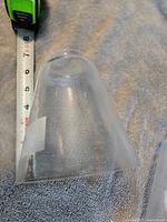 Single clear seeded glass cone shade with measuring tape for scale