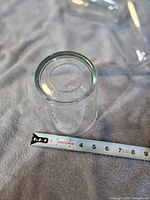 Single clear glass shade measured with tape showing dimensions