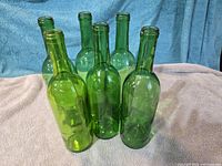 Seven of the green glass wine bottles grouped together to show color and style