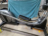 Left side profile of NordicTrack elliptical showing frame, rail and flywheel housing