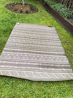 Full view of rug laid out on grass showing size and pattern