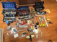 Overview of three toolboxes and spread-out tools on floor