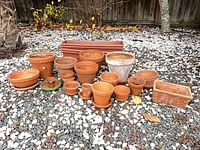 Full group of terracotta pots, saucers, window boxes displayed on ground