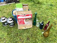 Full lot showing lanterns, boxed string lights, tote and bottles